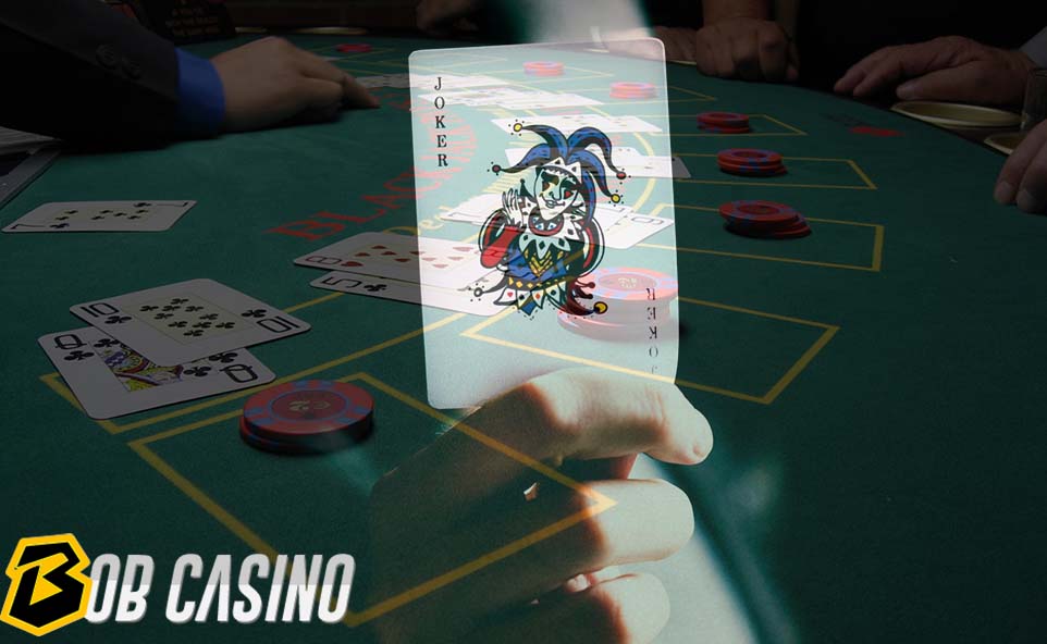 Man holding joker card in hand while playing poker