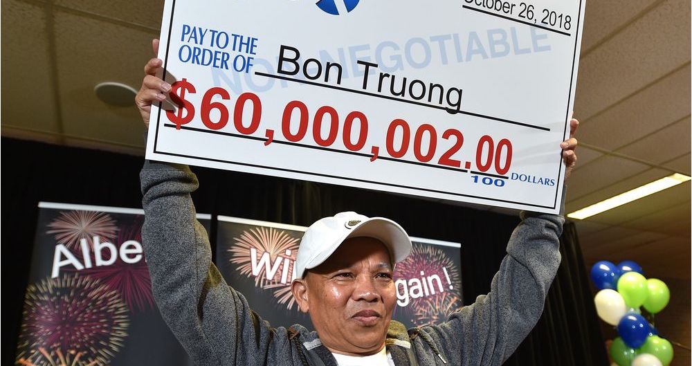 Bon Troung is holding his winning lottery cheque, after 30 years of betting on the same numbers.